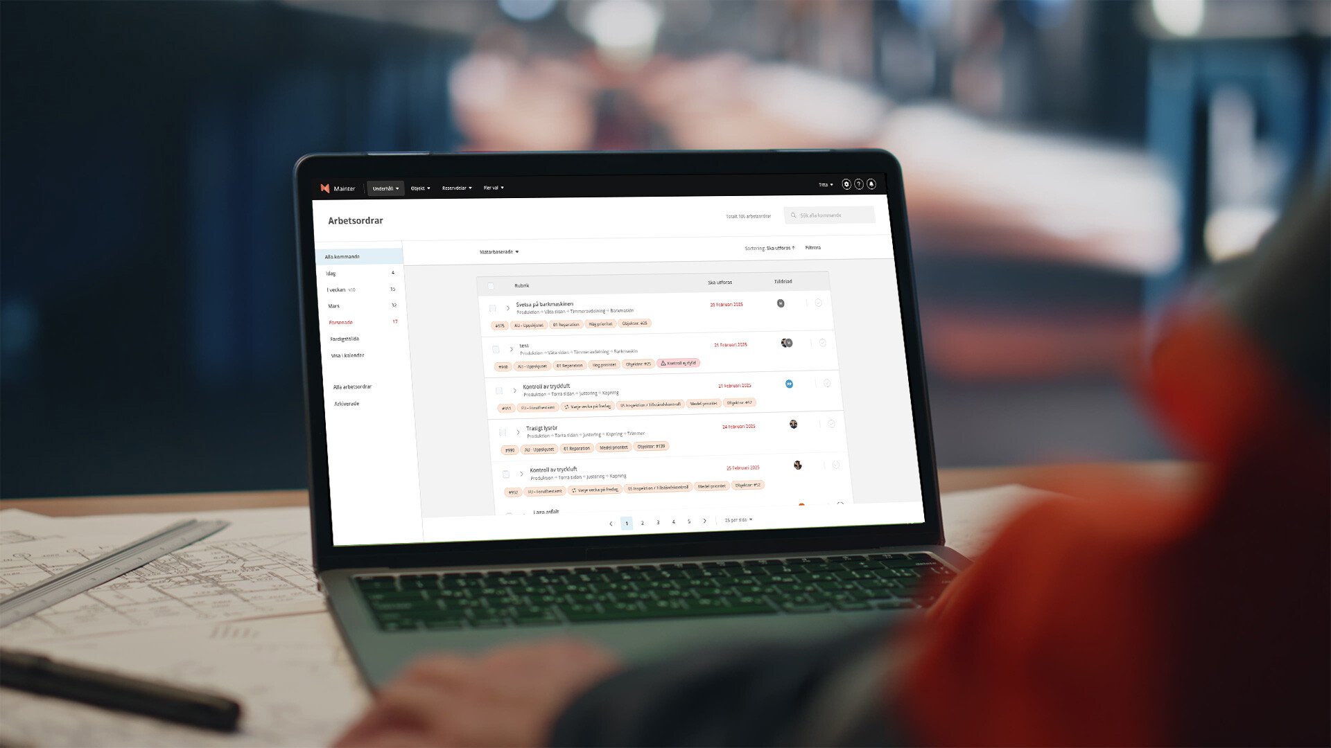 Laptop som visar arbetsorderfunktionen i Mainters CMMS-system, placerad på ett skrivbord i en industriell kontorsmiljö.