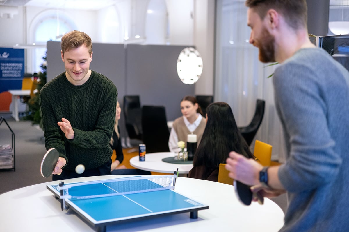 coworkers play ping pong at work